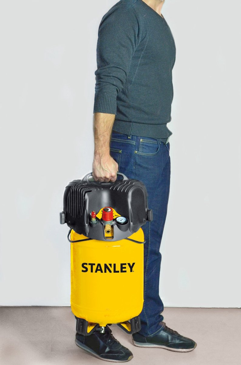 Uomo tiene compressore giallo Stanley con coperchio nero e manometro.