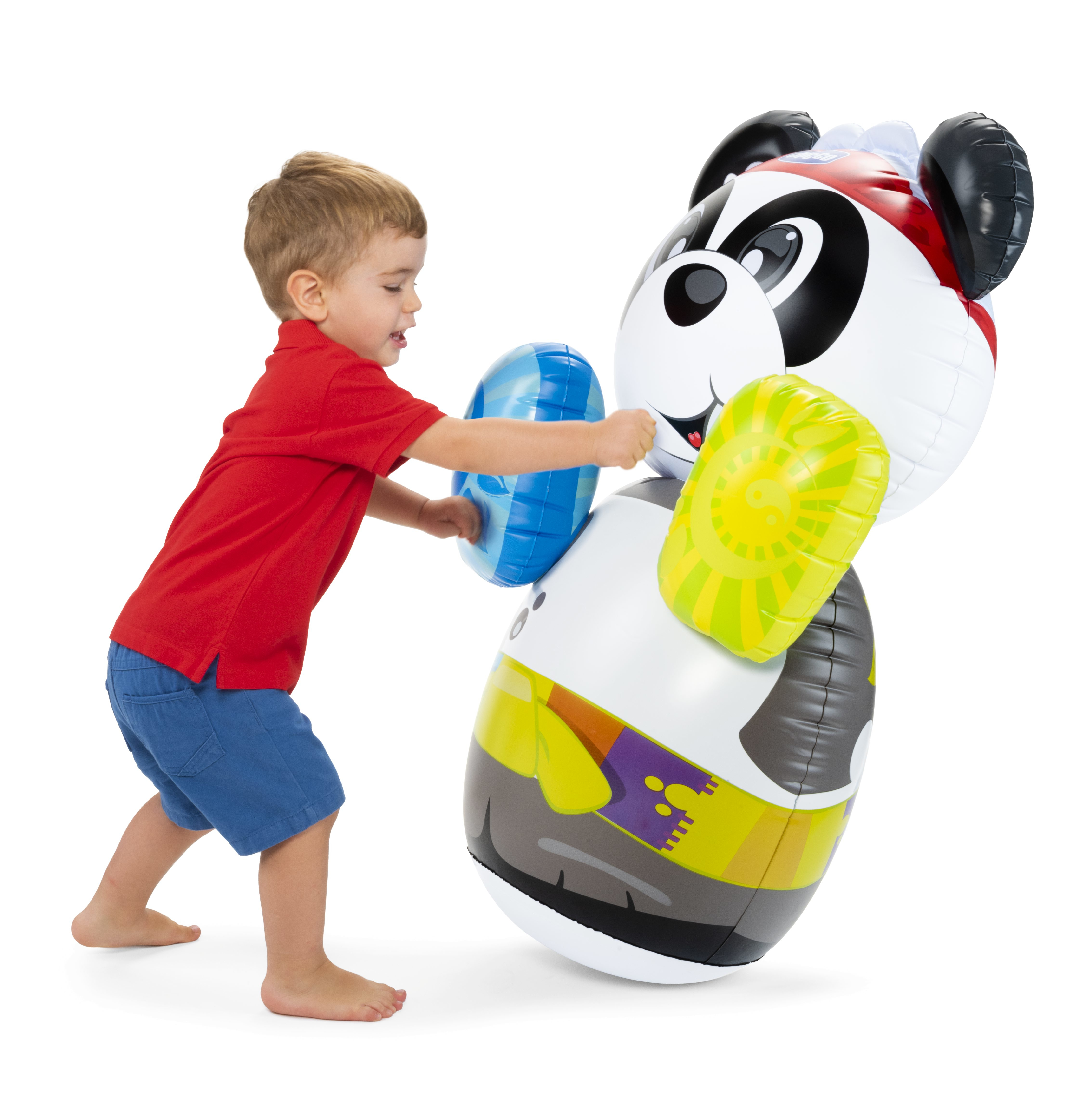 Un niño pequeño con camisa roja y pantalones cortos azules empuja un panda inflable.