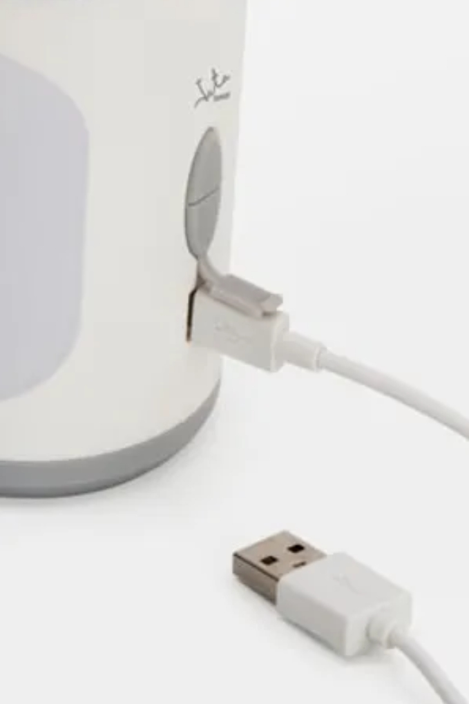 Un cable USB blanco está conectado a un dispositivo blanco con detalles grises.