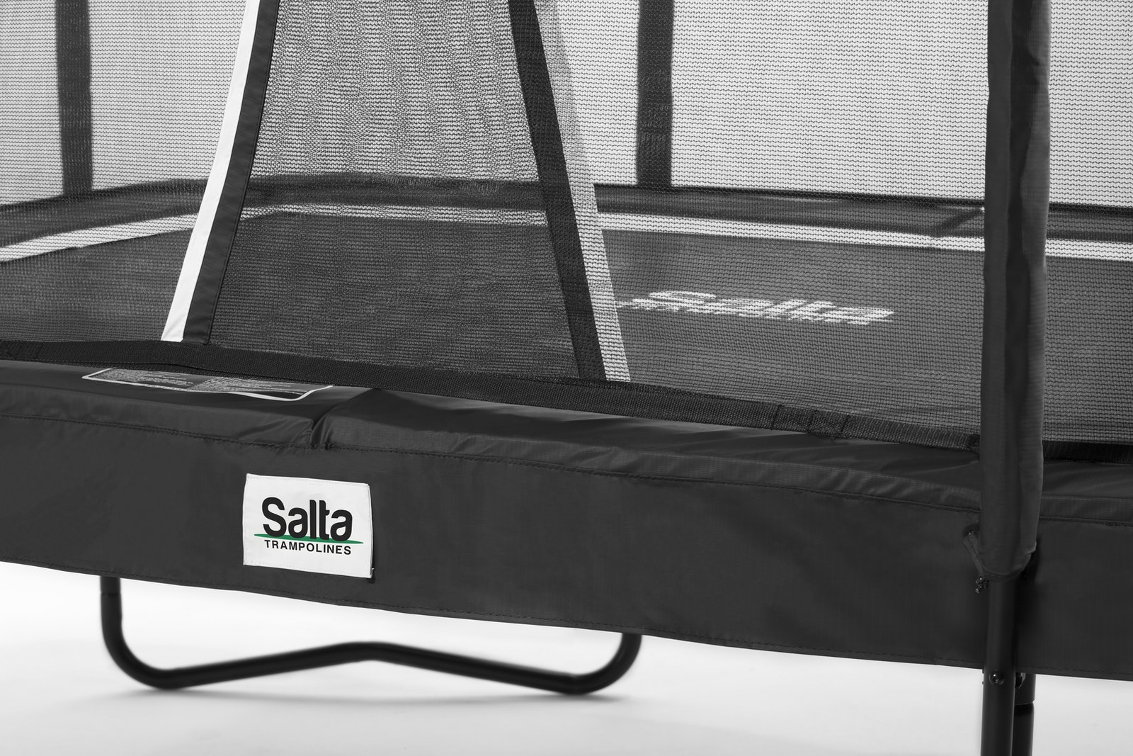 Zbliżenie czarnej trampoliny z siatką zabezpieczającą i logo Salta.