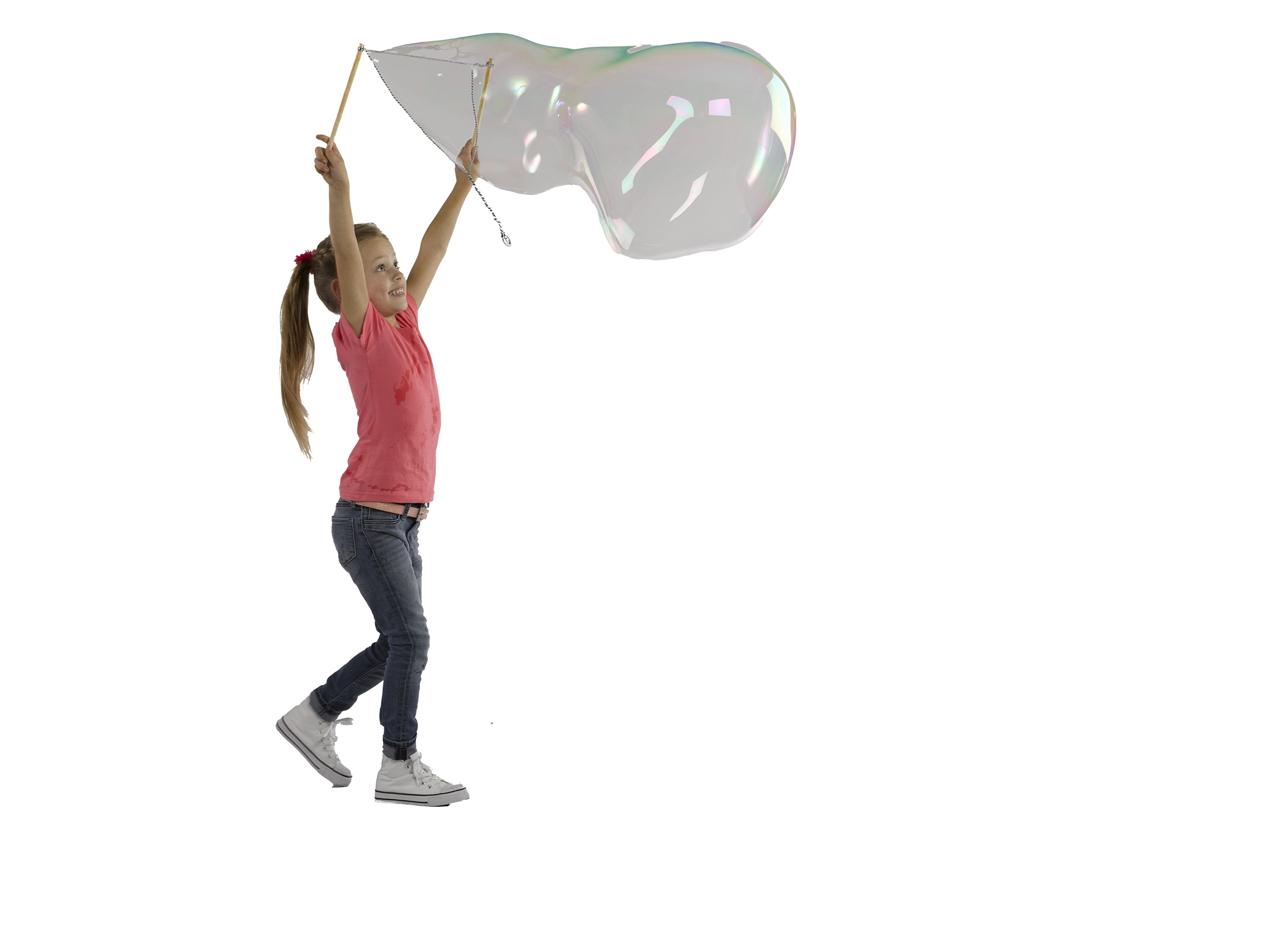 Una ragazza in jeans e maglietta rosa fa bolle con una bacchetta.