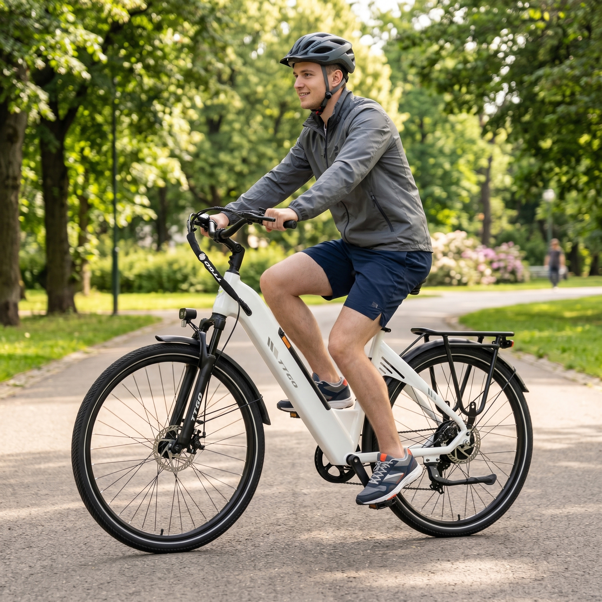 Ein Mann fährt ein weißes E-Bike auf einem Weg im Park.