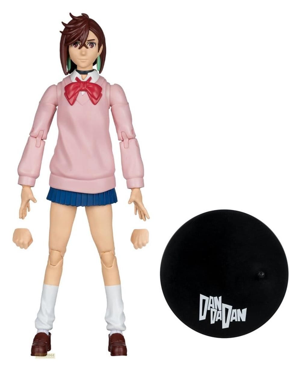 Eine Actionfigur eines Mädchens in einem rosa Pullover, blauem Rock und weißen Socken.