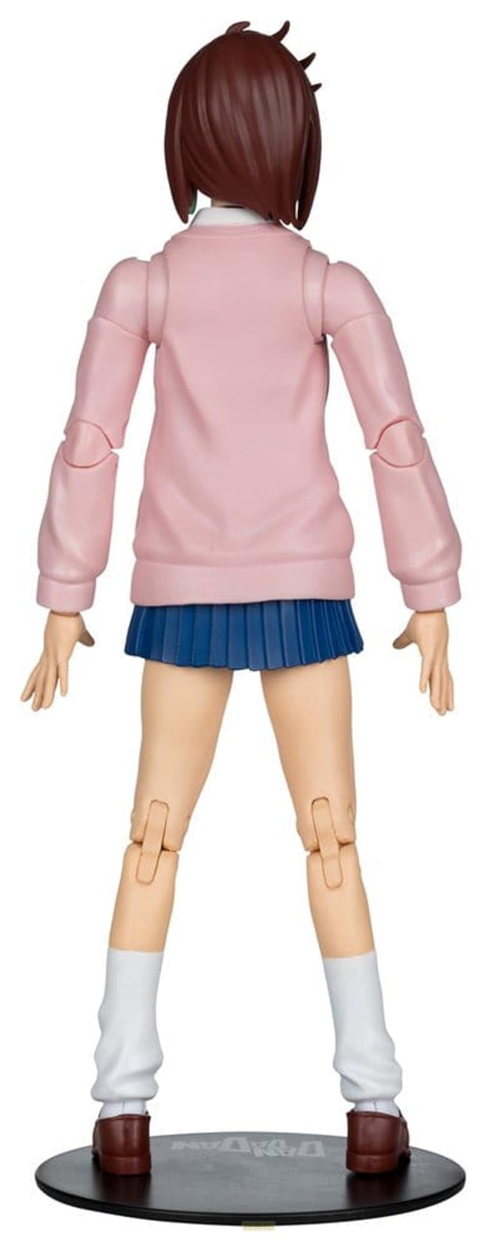 Eine Figur mit braunen Haaren trägt einen rosa Pullover und einen blauen Faltenrock.