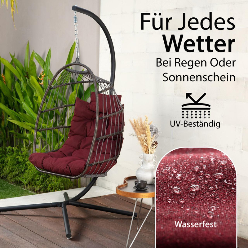 Ein Hängesessel mit burgunderroter Polsterung steht draußen auf einer Holzterrasse.