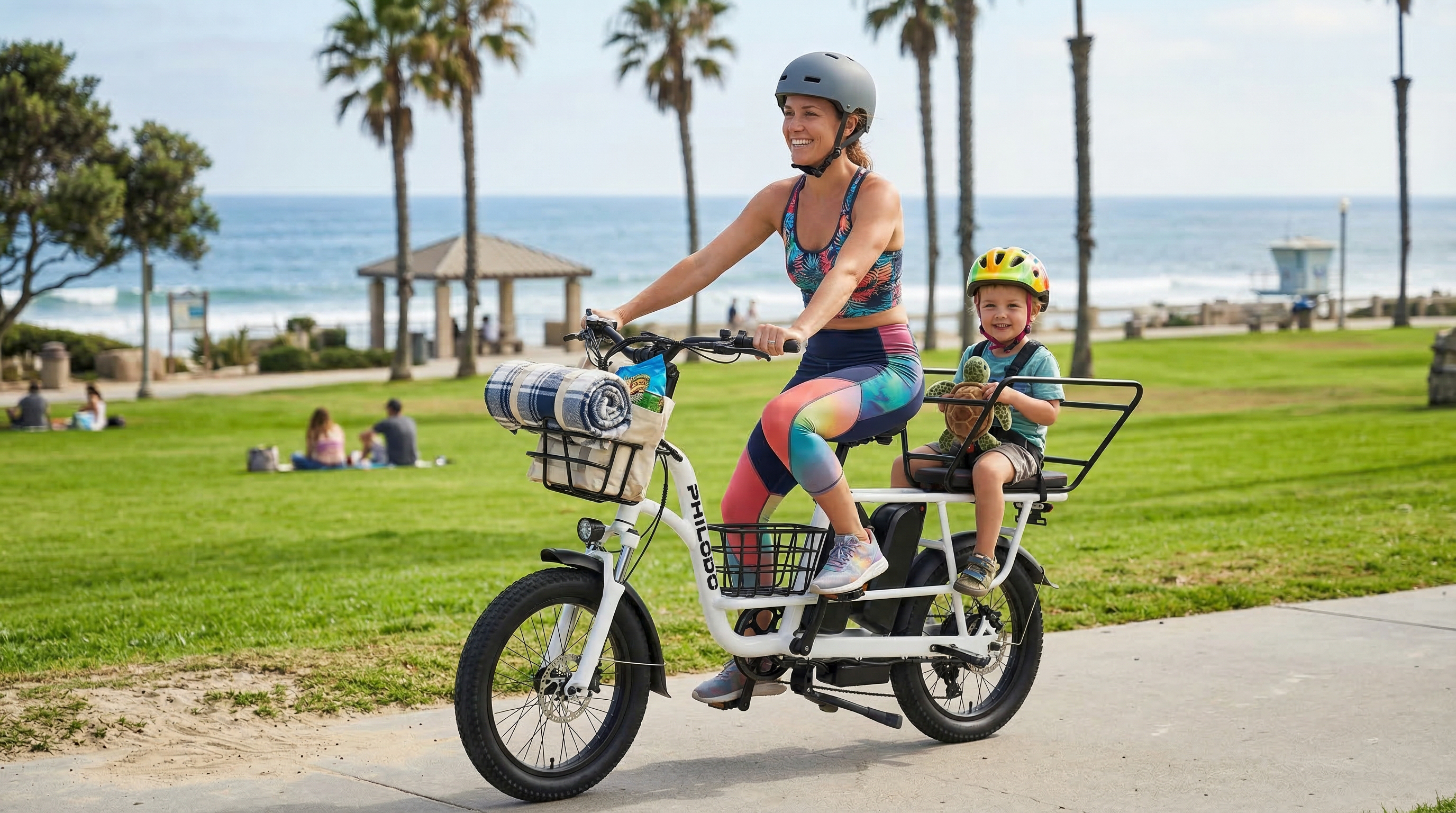 Donna e bambino guidano e-bike bianca vicino alla spiaggia con palme. Mare sullo sfondo.
