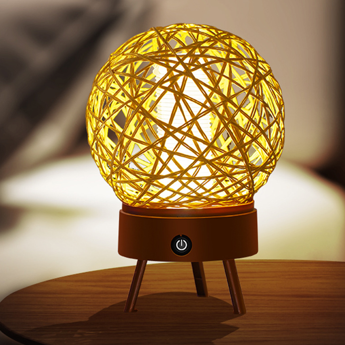 Eine kugelförmige Lampe aus gelbem Gewebe mit einem braunen Sockel und drei Beinen.
