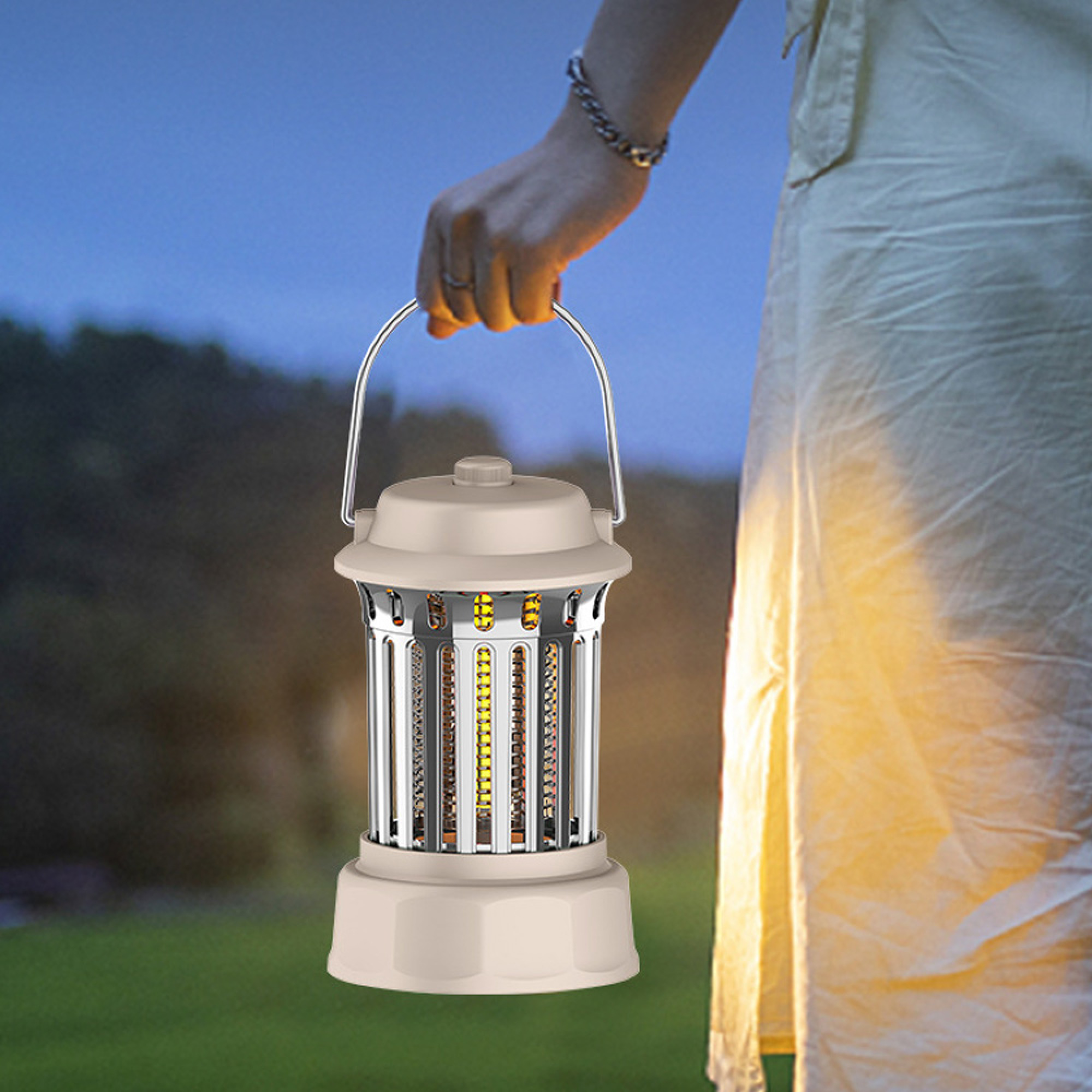 Eine Person in heller Kleidung hält eine leuchtende Insektenlampe mit Metallgriff vor dunklem blauen Himmel und grünem Gras.
