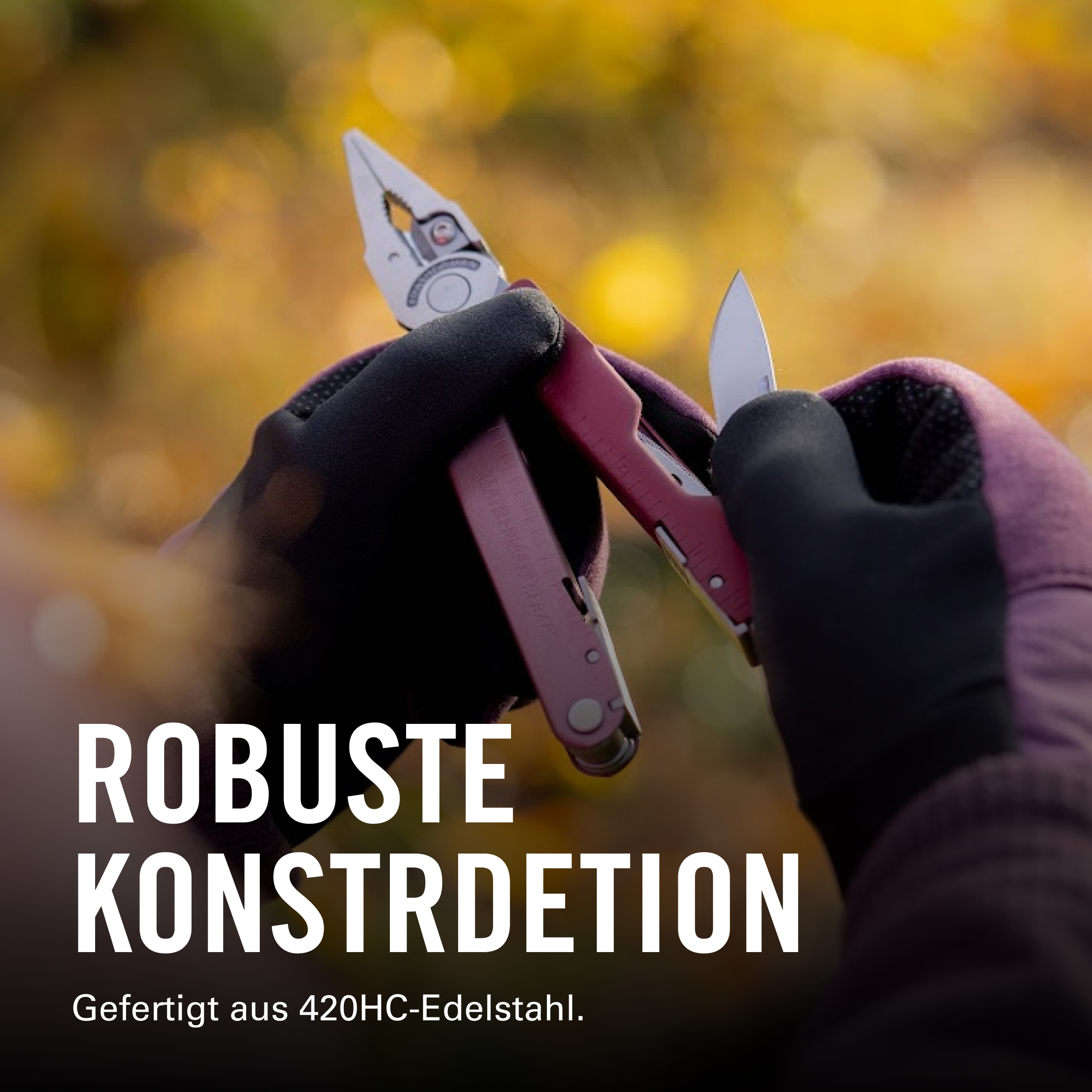 Eine Person mit schwarzen und lila Handschuhen hält ein Multitool mit Zange und ausgeklappter Messerklinge vor einem verschwommenen Herbsthintergrund.