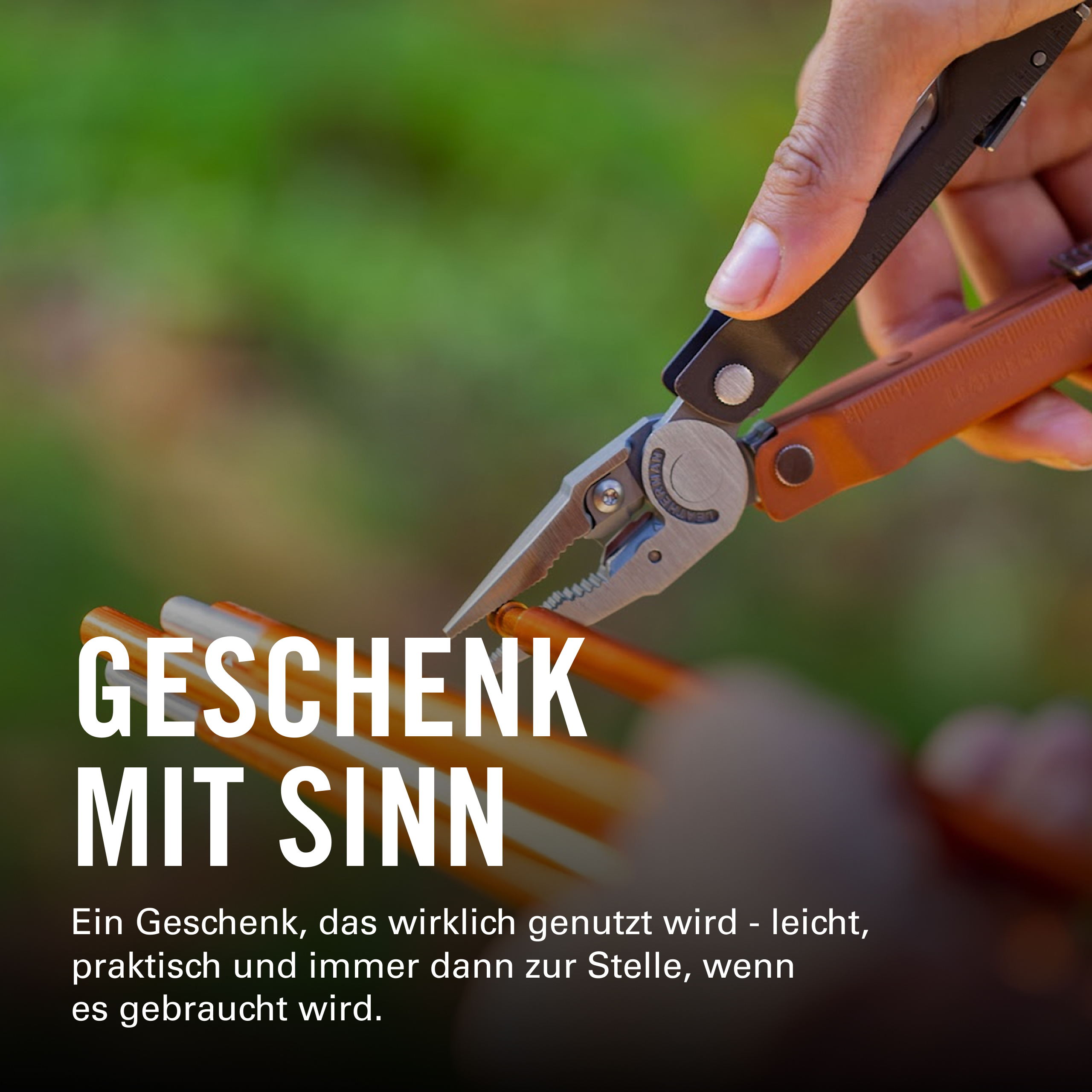 Eine Hand hält ein Multitool, das einen orangefarbenen Gegenstand greift.