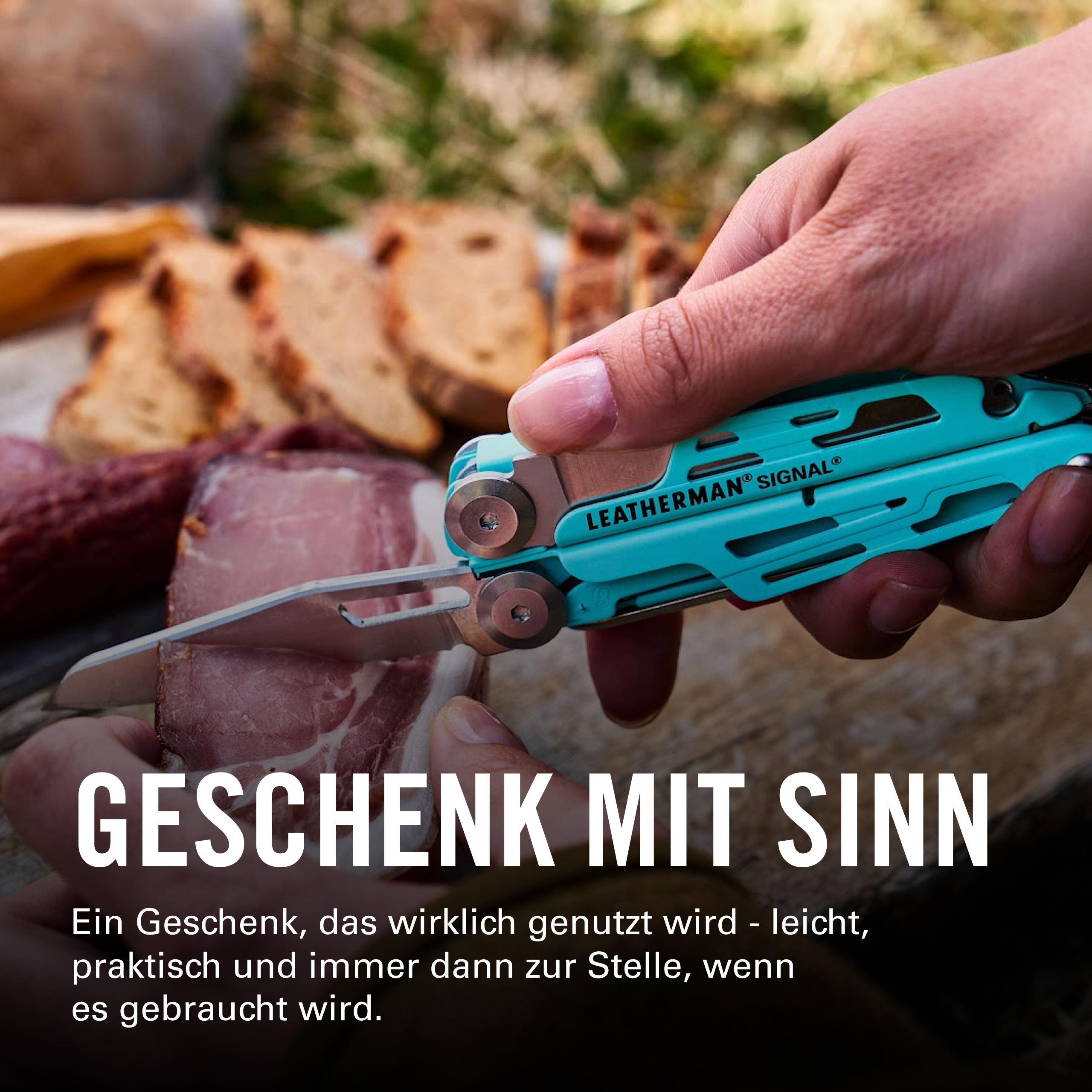 Eine Hand hält ein türkisfarbenes Multitool und schneidet eine Scheibe Wurst, mit Brot im unscharfen Hintergrund im Freien.