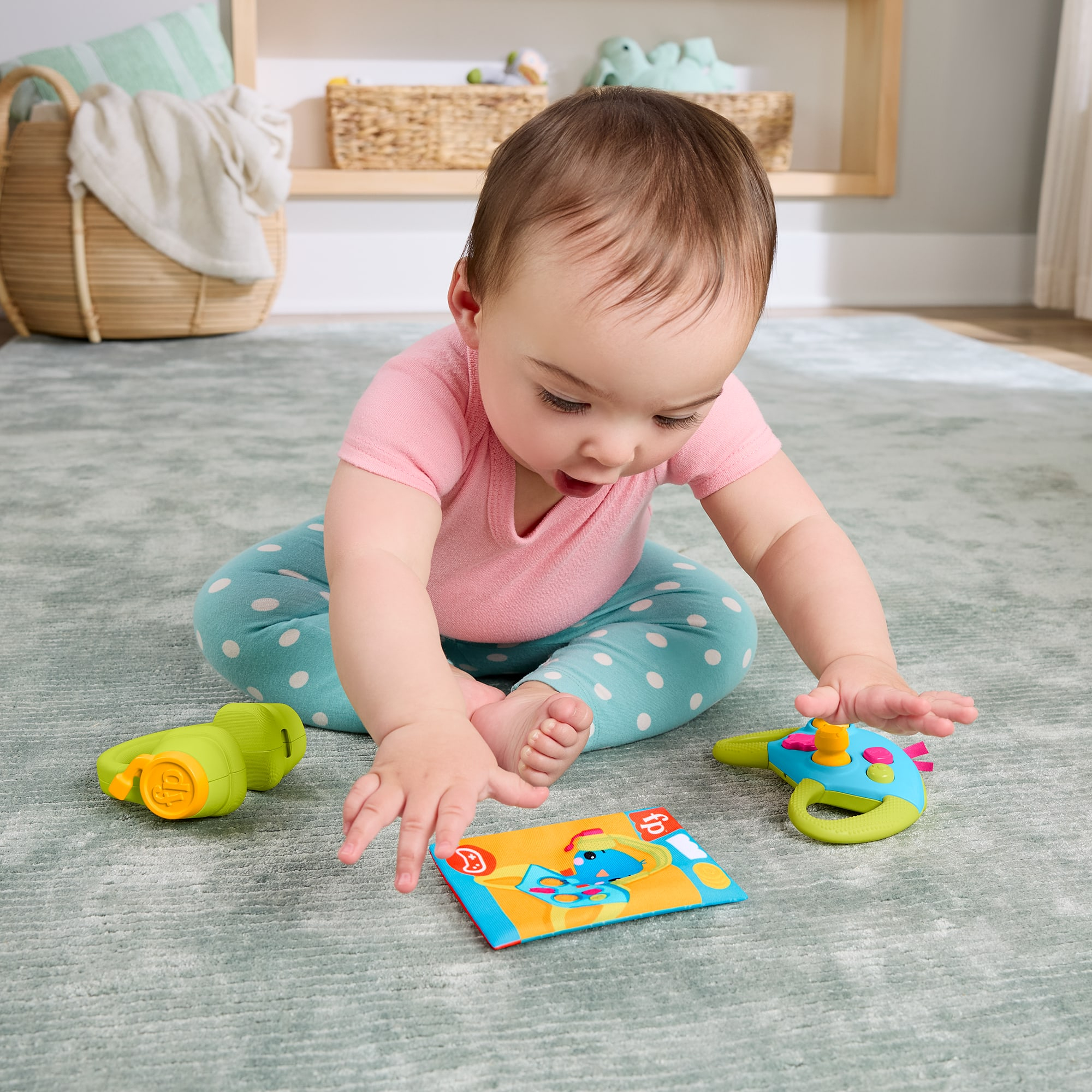 Ein Baby in einem pinken Hemd und gepunkteter Hose spielt mit Spielzeug auf einem Teppich.