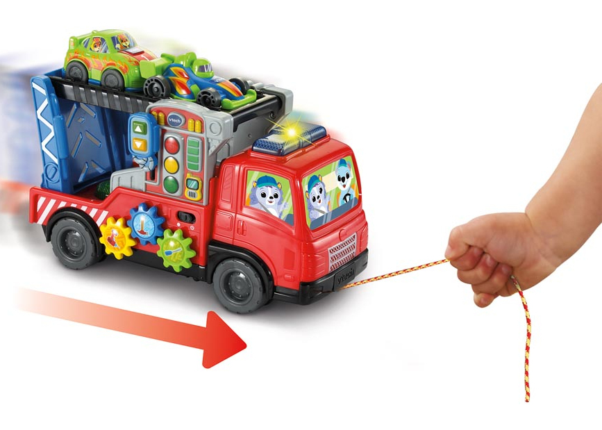 Ein Kind zieht einen roten Spielzeug-Abschleppwagen mit Autos und Zahnrädern.