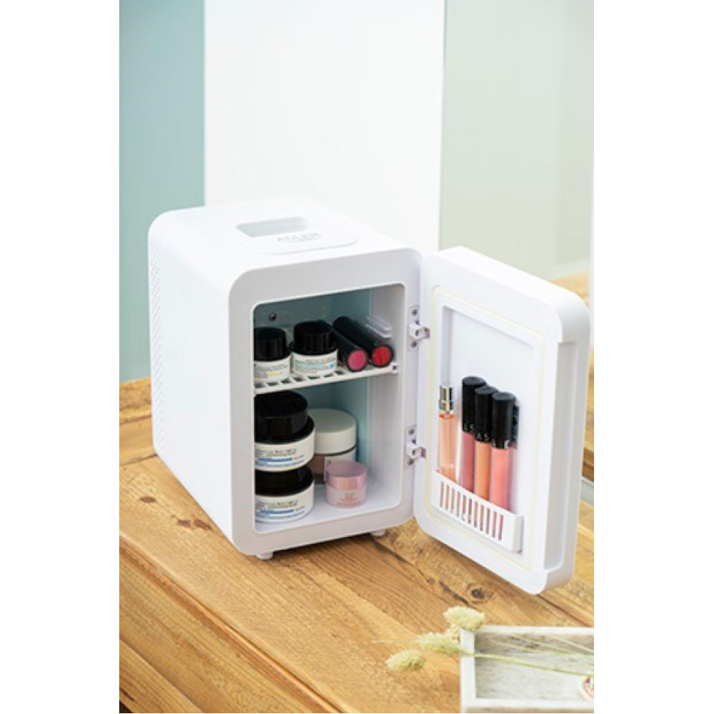 Un mini-frigo bianco su una superficie di legno, con la porta aperta che rivela prodotti per la cura della pelle e lucidalabbra all'interno.