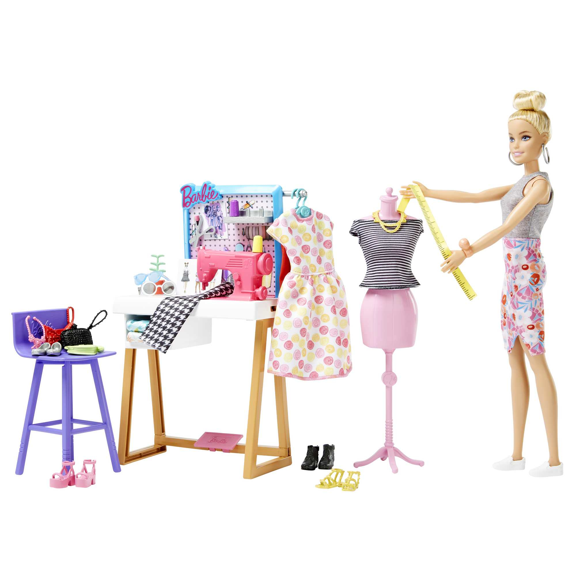 Barbie als Modedesignerin mit Nähmaschine, Kleiderbügel, Puppen und Zubehör.