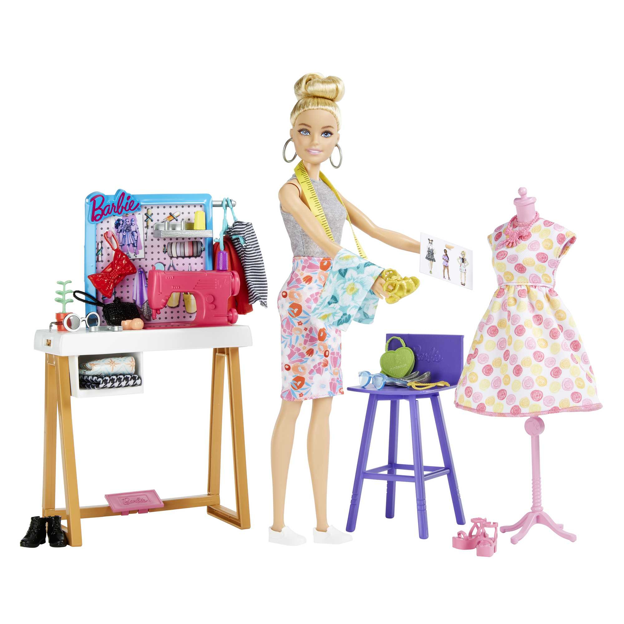 Barbie-Puppe mit Nähplatz, Stoffen, Nähmaschine und Kleid auf Schaufensterpuppe.