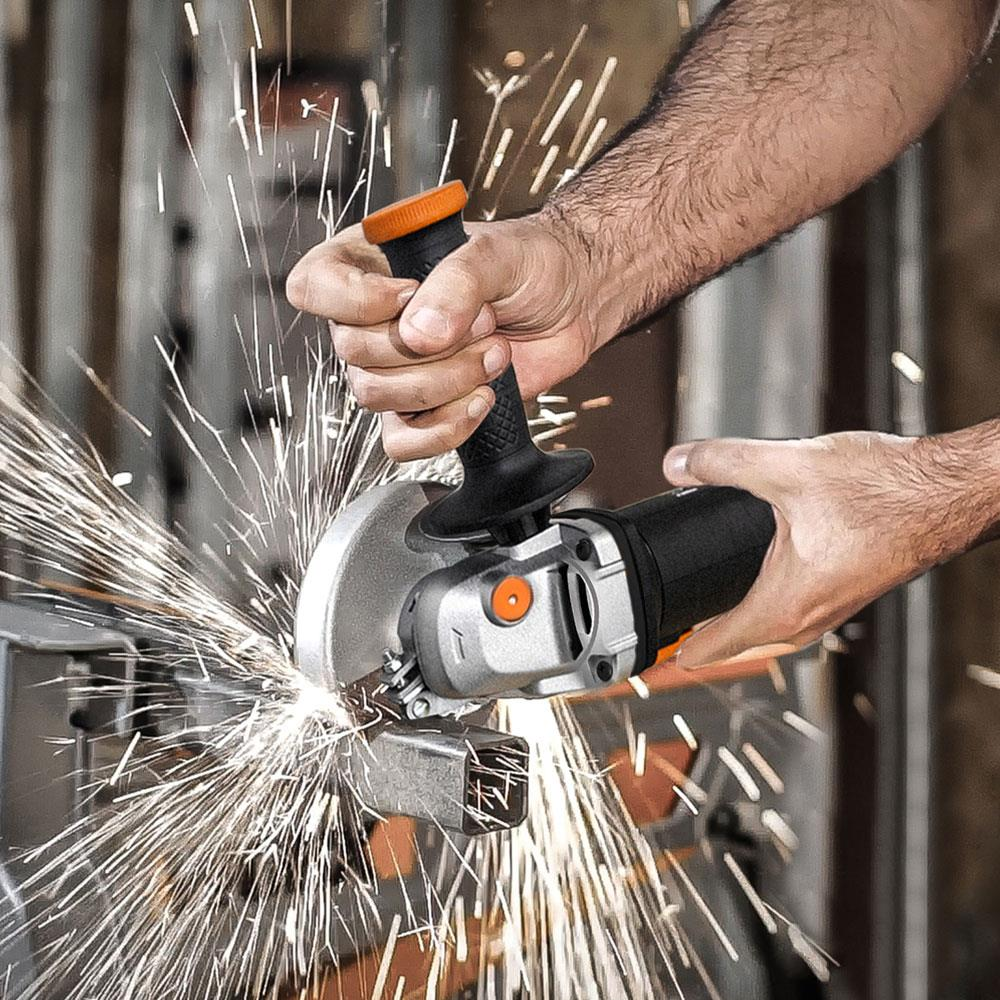 Bir kişi metal boru keserken bolca kıvılcım çıkaran bir avuç taşlama makinesi kullanıyor.
