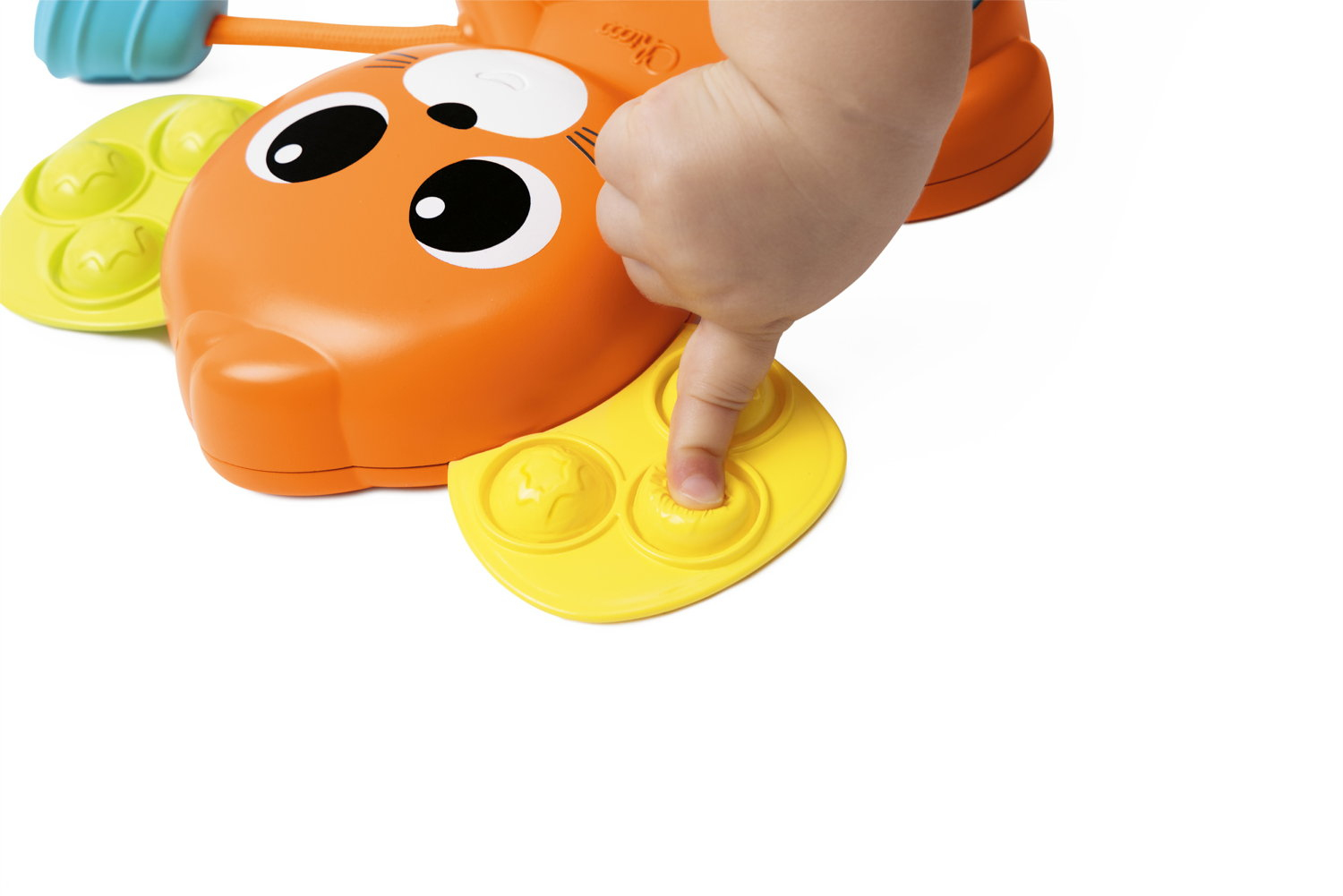 Eine Babyhand drückt einen gelben Knopf auf einem orangefarbenen Spielzeug mit großen Augen und grünen und blauen Akzenten.