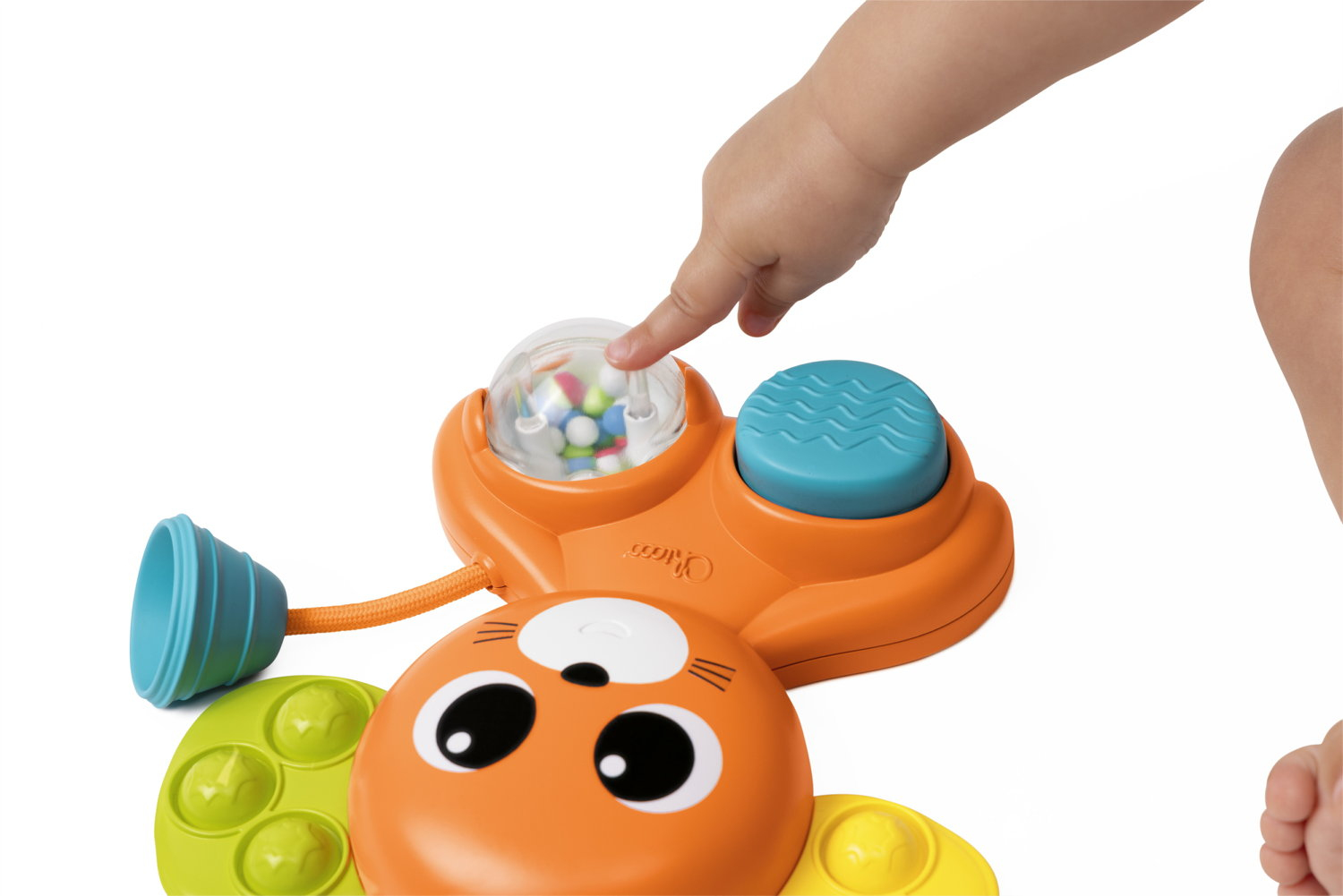 Ein Kinderfinger drückt auf eine transparente Kugel mit bunten Perlen auf einem orangefarbenen Spielzeug.