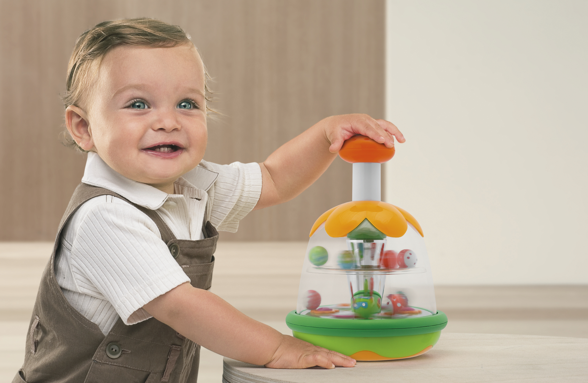 Ein Baby lacht und spielt mit einem bunten Spielzeug, das sich dreht.