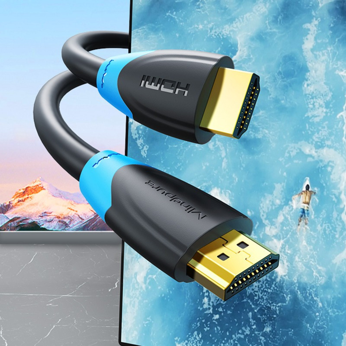 Ein HDMI-Kabel mit goldenen Anschlüssen schlängelt sich vor einer Bergkulisse und dem Meer.