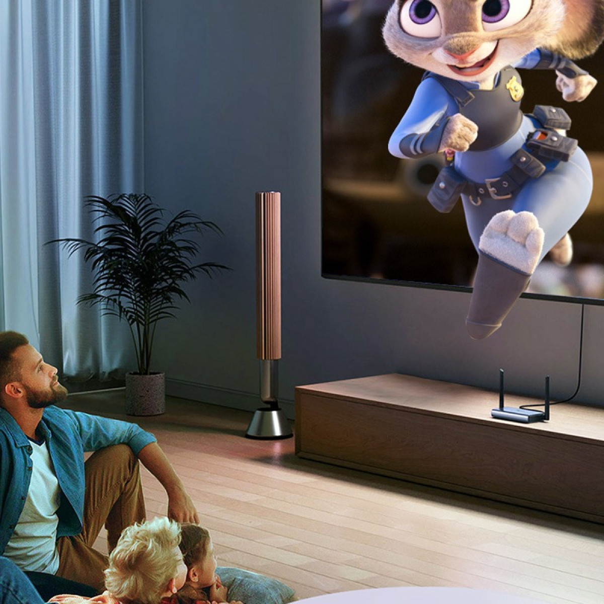 Familie schaut Zeichentrickfilm auf großem Fernseher im Wohnzimmer.