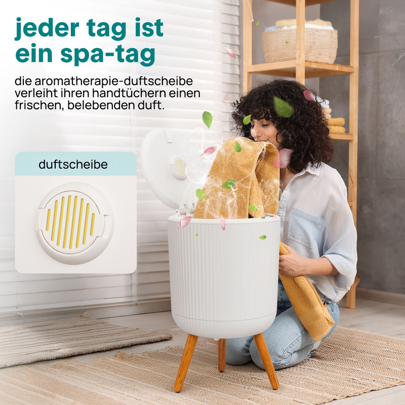 Eine Frau riecht an einem duftenden Handtuch aus einem weißen Diffusor mit Holzbeinen.