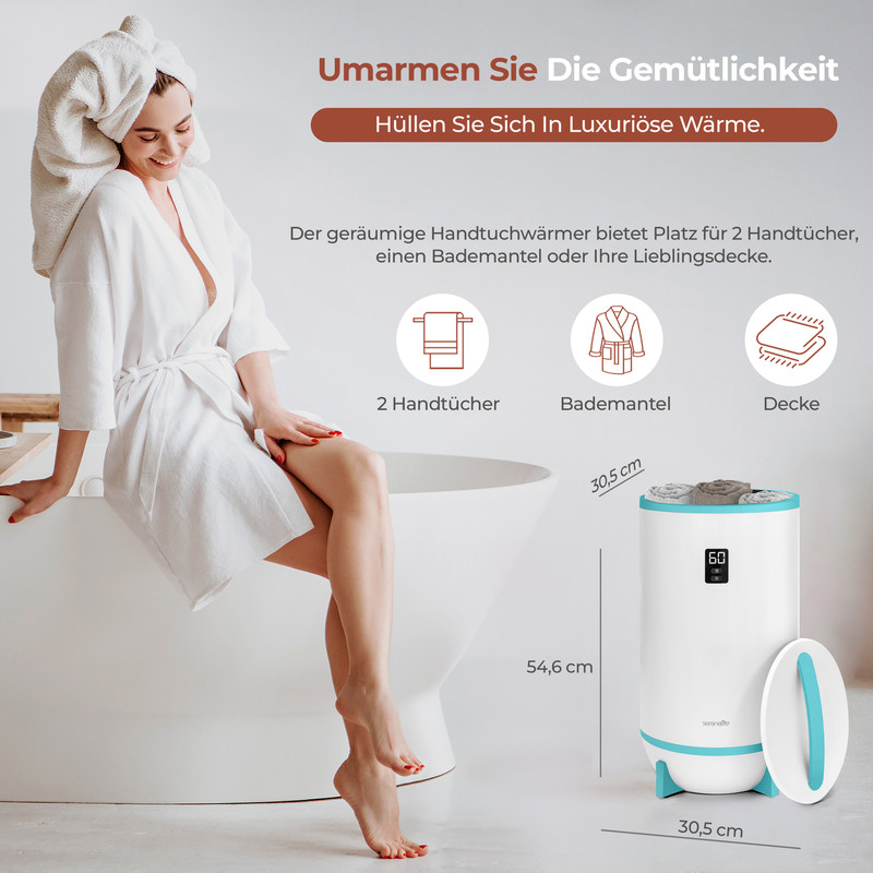 Eine Frau in weißem Bademantel und Handtuchturban sitzt lächelnd auf einer weißen Badewanne, neben einem Handtuchwärmer.