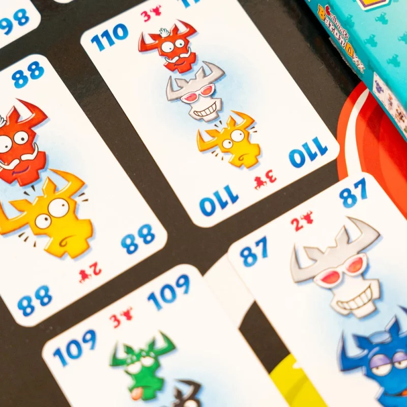 Nahaufnahme von Spielkarten mit Cartoon-Stierfiguren in Rot-, Gelb-, Grau-, Grün- und Blautönen.