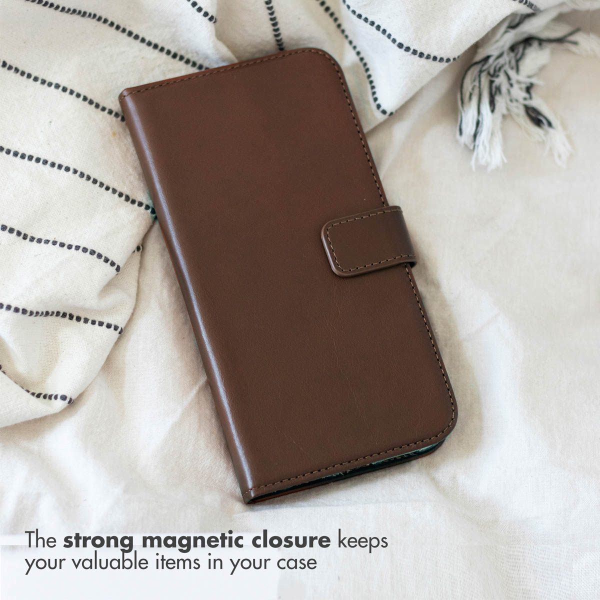 Custodia flip in pelle marrone con chiusura magnetica su tessuto a righe.
