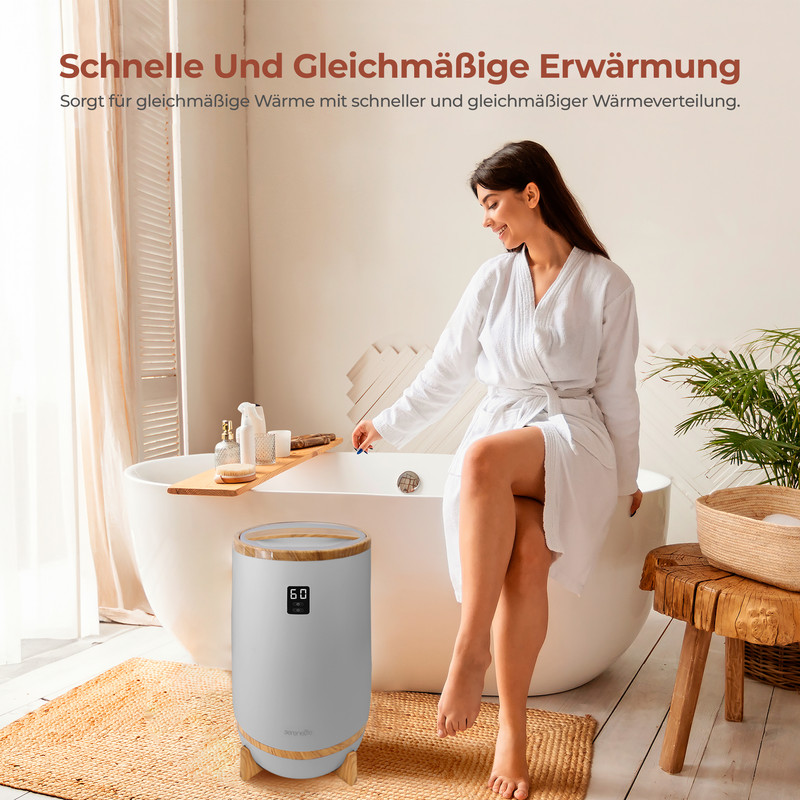 Frau im Bademantel am Wannenrand, neben grauem Heizgerät mit Digitalanzeige 60.