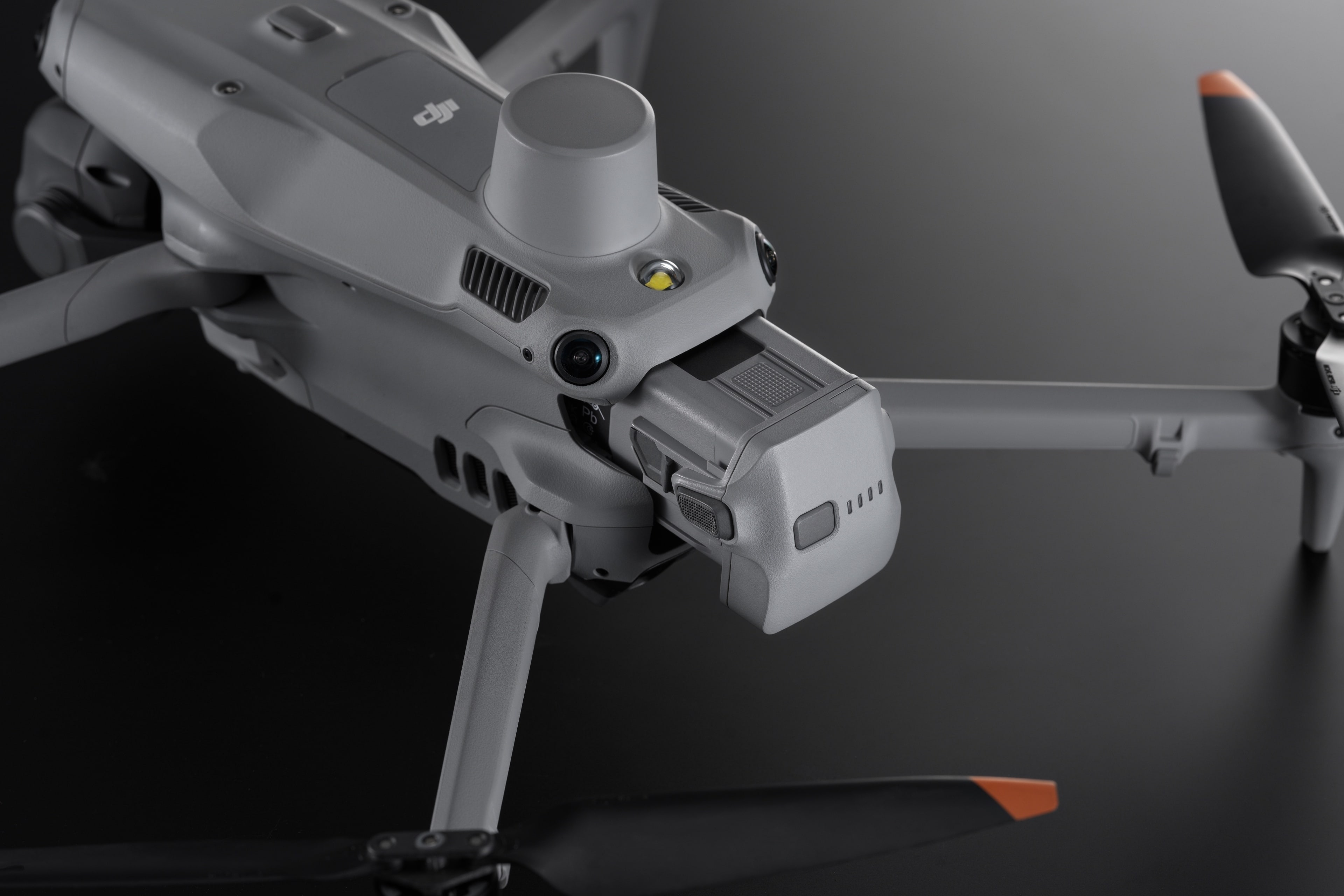 Drone DJI Mavic 3 grigio con telecamere ed eliche su sfondo scuro.