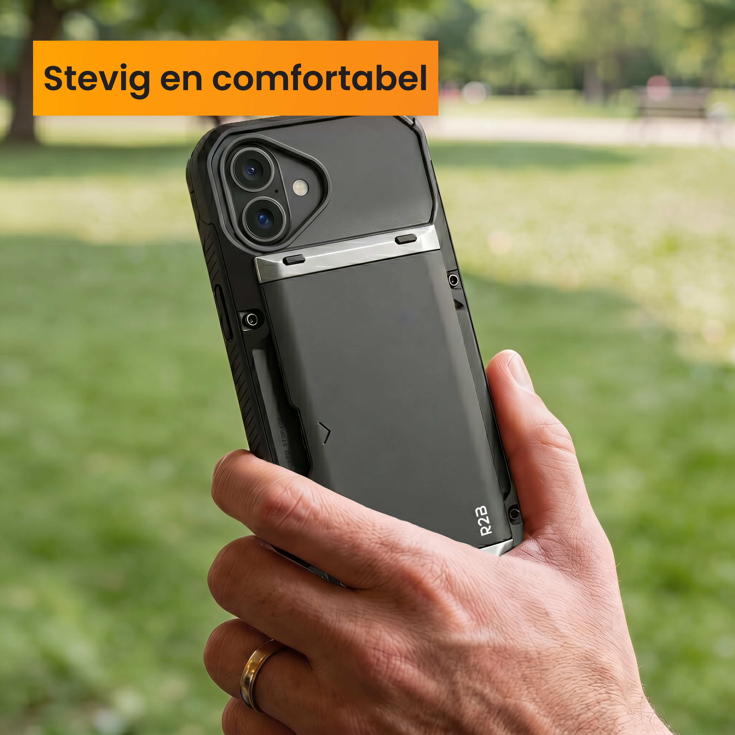 A hand holds a black phone with a card slot on the back, outdoors.
