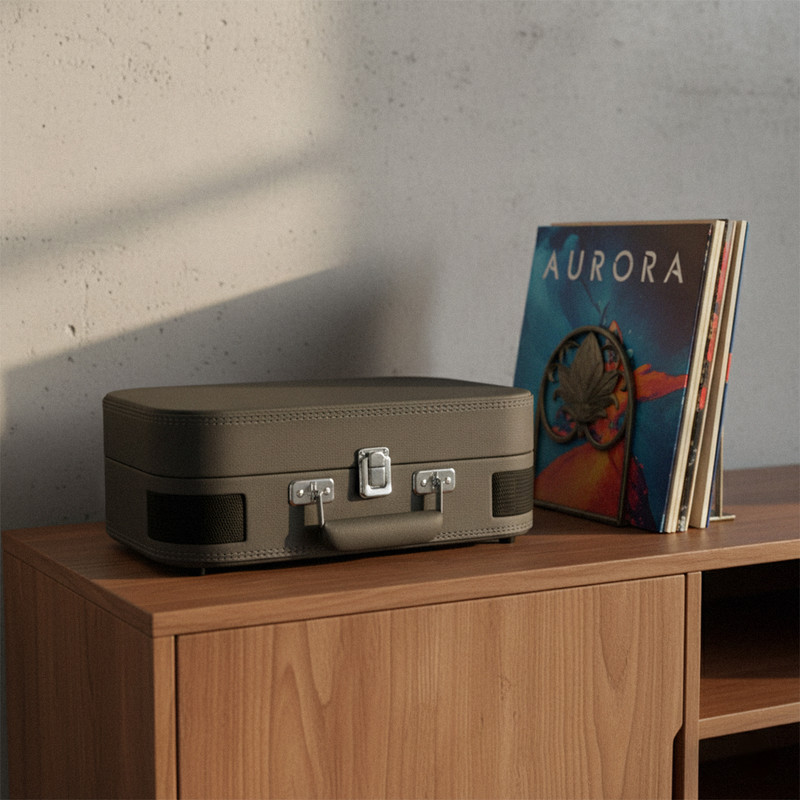 Un tocadiscos gris está sobre un mueble de madera junto a discos.