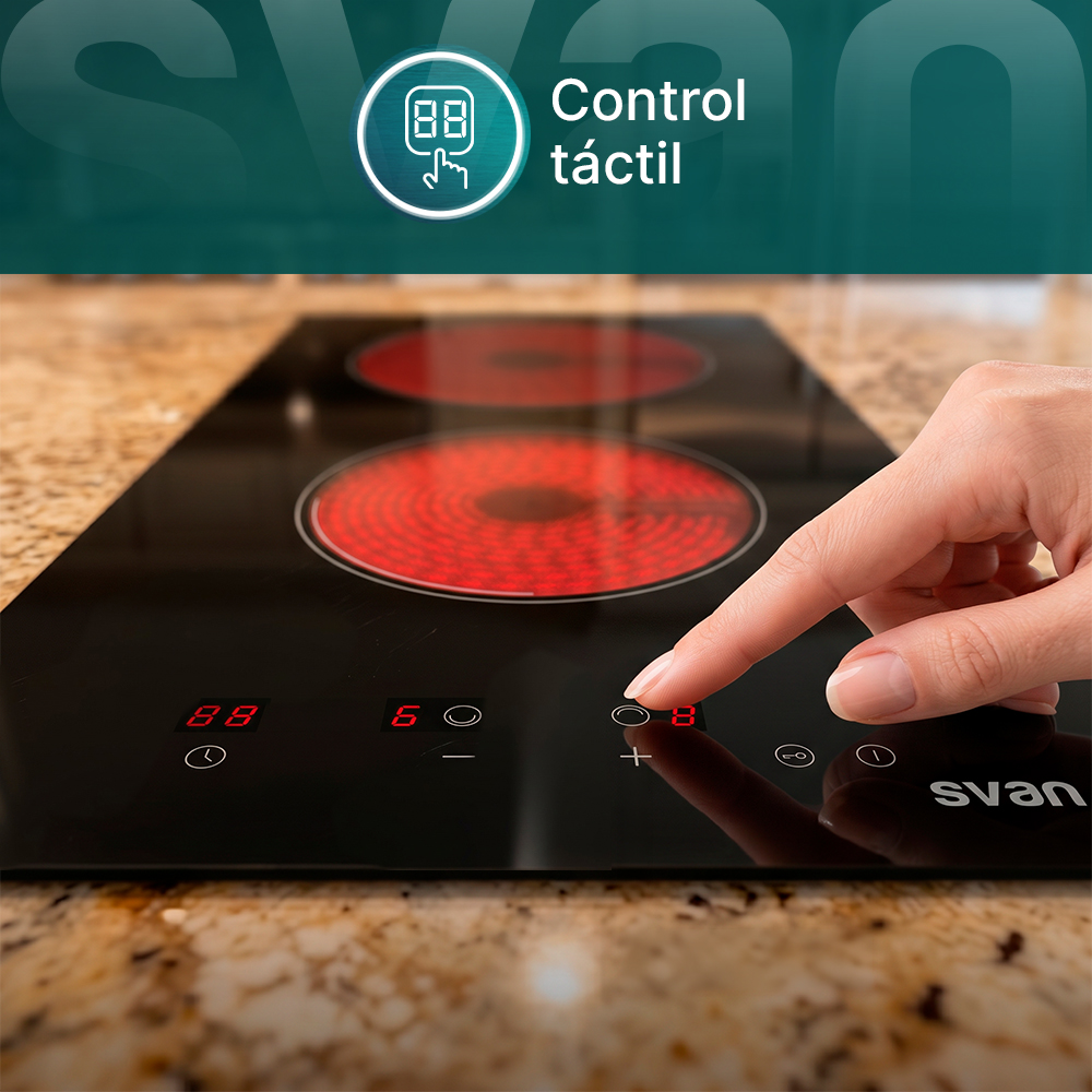 Una mano opera una placa de cocina con elementos calefactores rojos y pantalla digital.