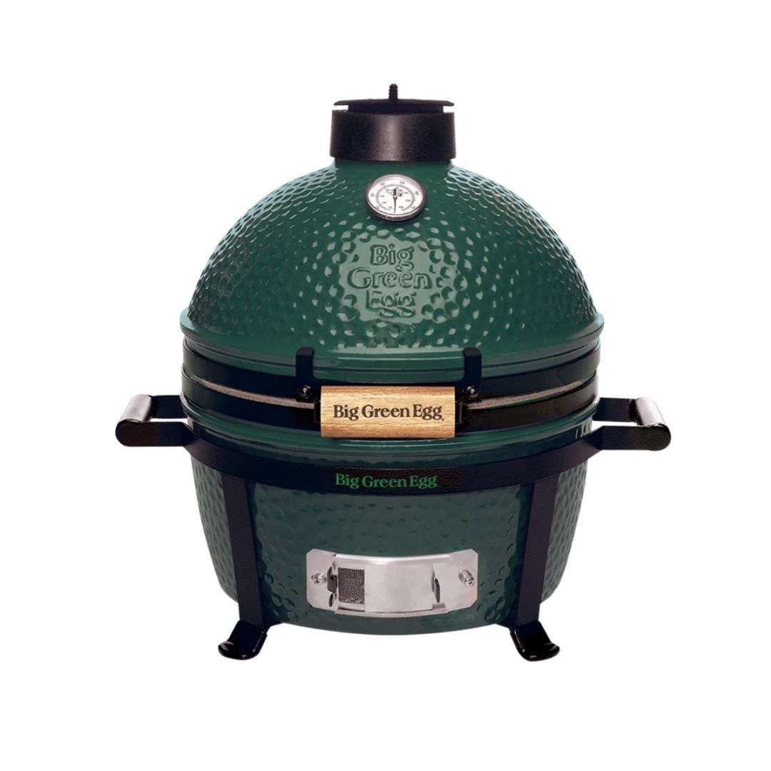 Üstünde termometresi ve ahşap kulpları olan yeşil Big Green Egg ızgara.