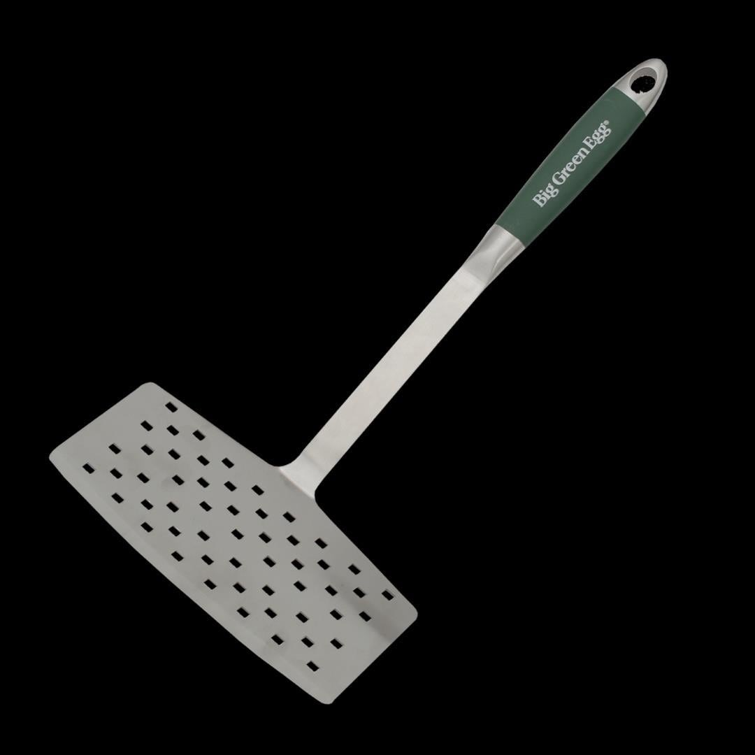 Siyah zemin üzerinde, "Big Green Egg" logolu koyu yeşil saplı paslanmaz çelik delikli bir spatula.