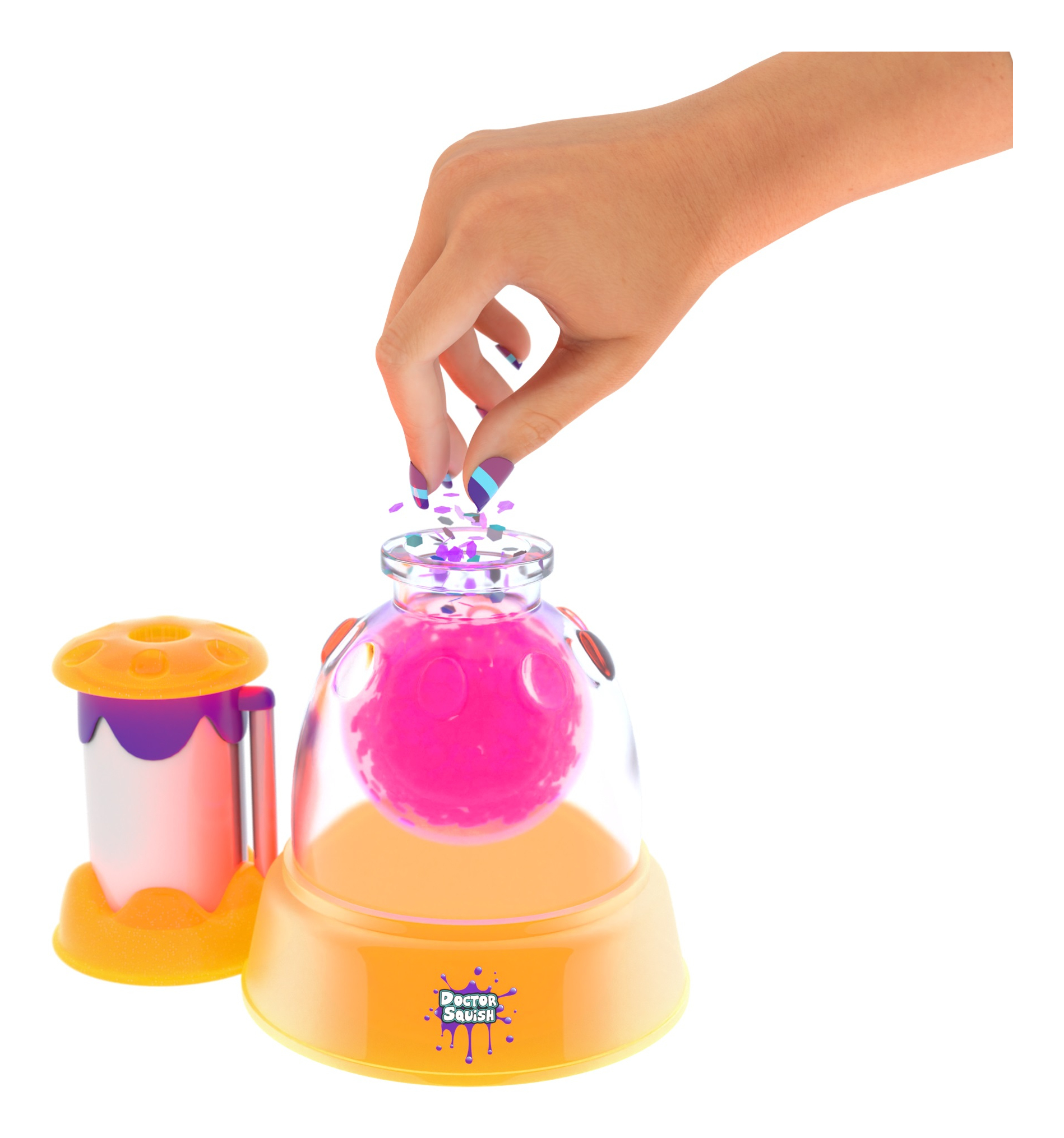Una mano esparce partículas coloridas en un frasco con bola rosa.