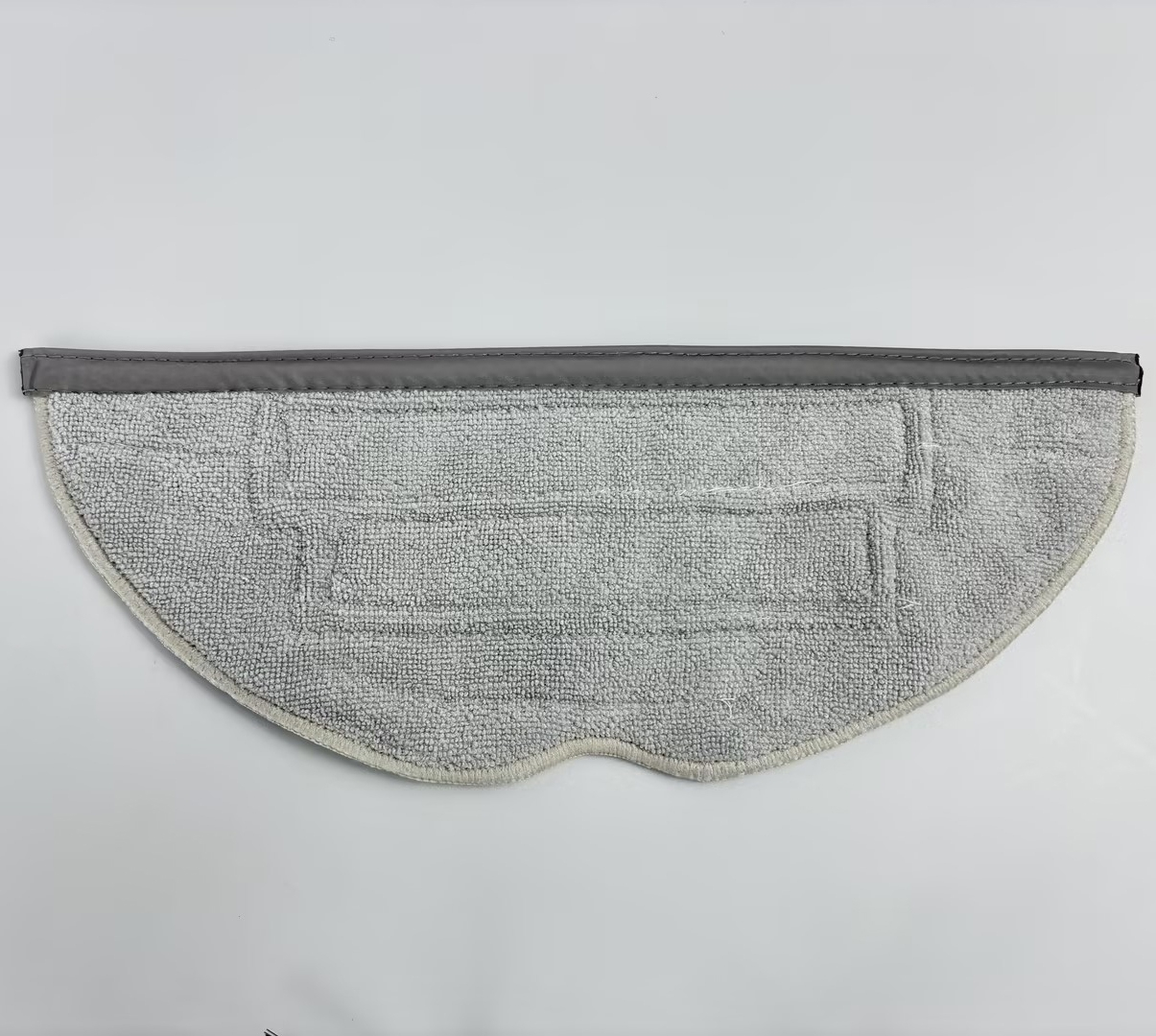 A gray mop pad with a textured surface and a dark gray border is shown.