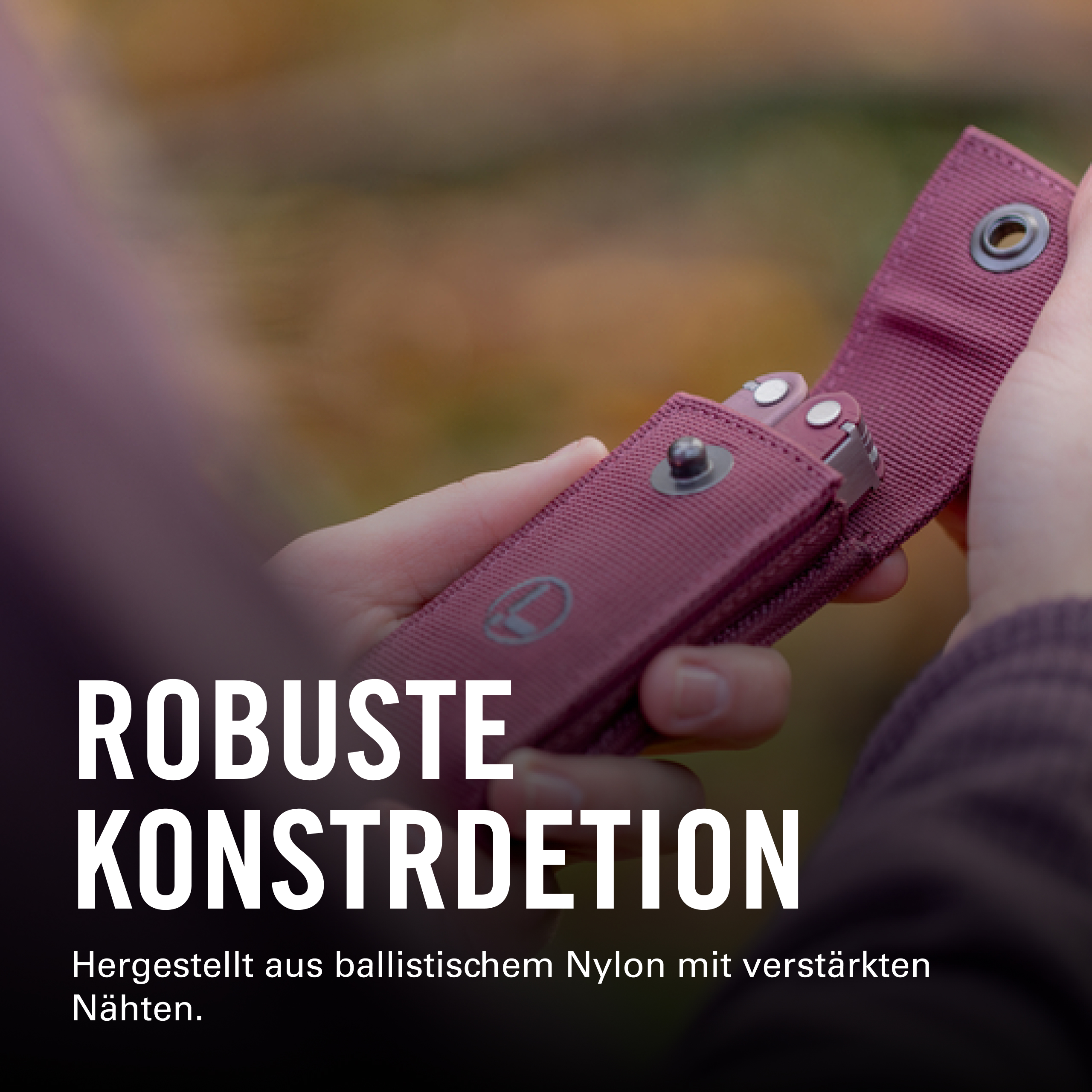 Eine Hand hält ein rosafarbenes Multi-Tool-Etui mit einem silbernen Knopf.