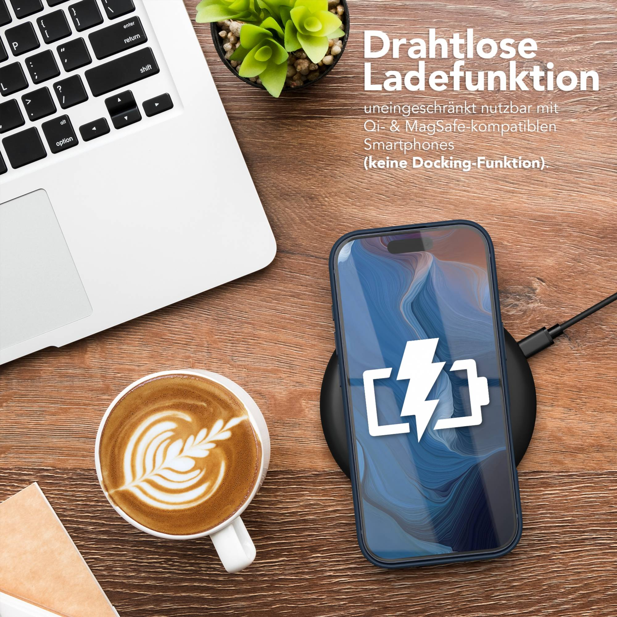 Ein Laptop, eine Kaffeetasse und ein Handy auf einer Ladestation auf einem Holztisch.