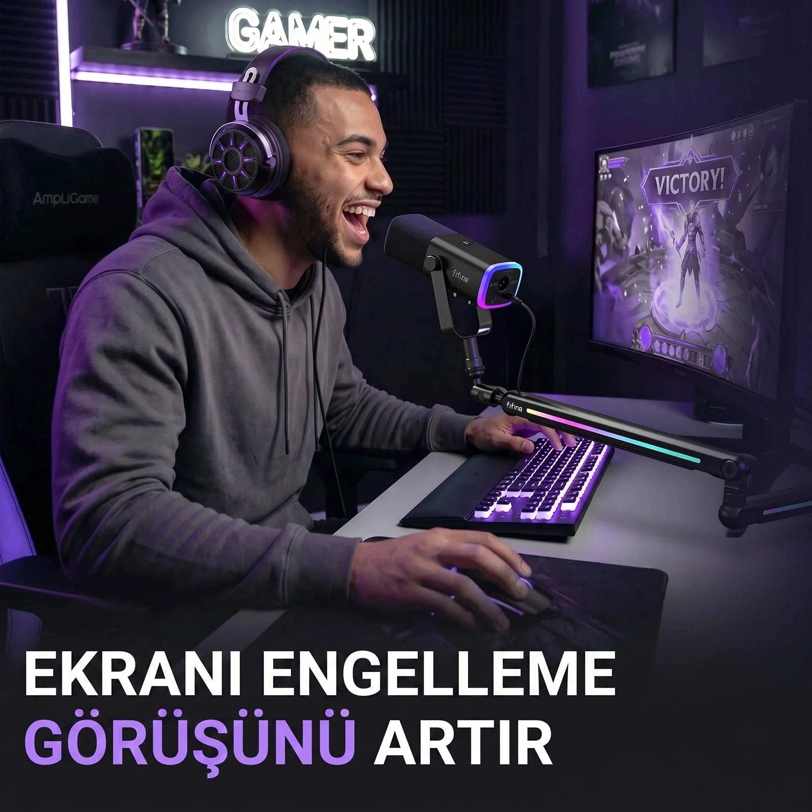 Gri kapüşonlu ve kulaklıklı bir adam aktif olarak oyun oynuyor, mor ışıkla aydınlanmış, "ZAFER!" ekranıyla.