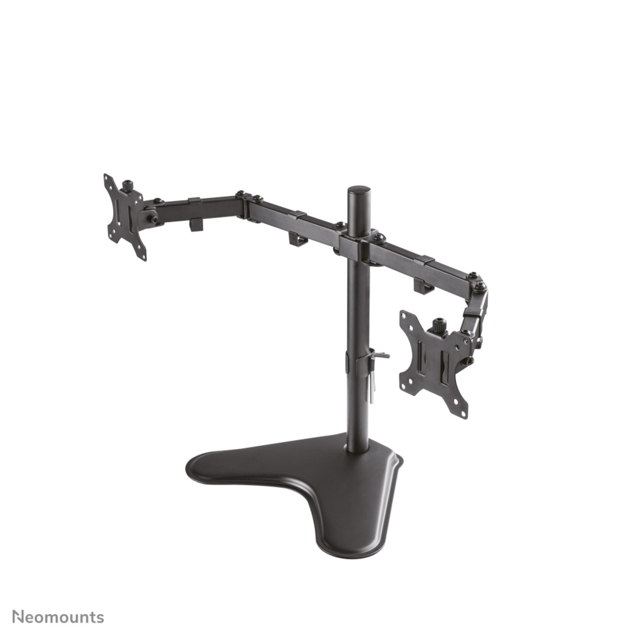 A black monitor stand with two adjustable arms extends from a central pole, resting on a flat, dark, irregularly shaped base.