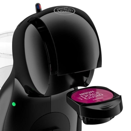 Una macchina da caffè Nescafé Dolce Gusto nera con una capsula di caffè espresso magenta inserita, pronta per l'erogazione.