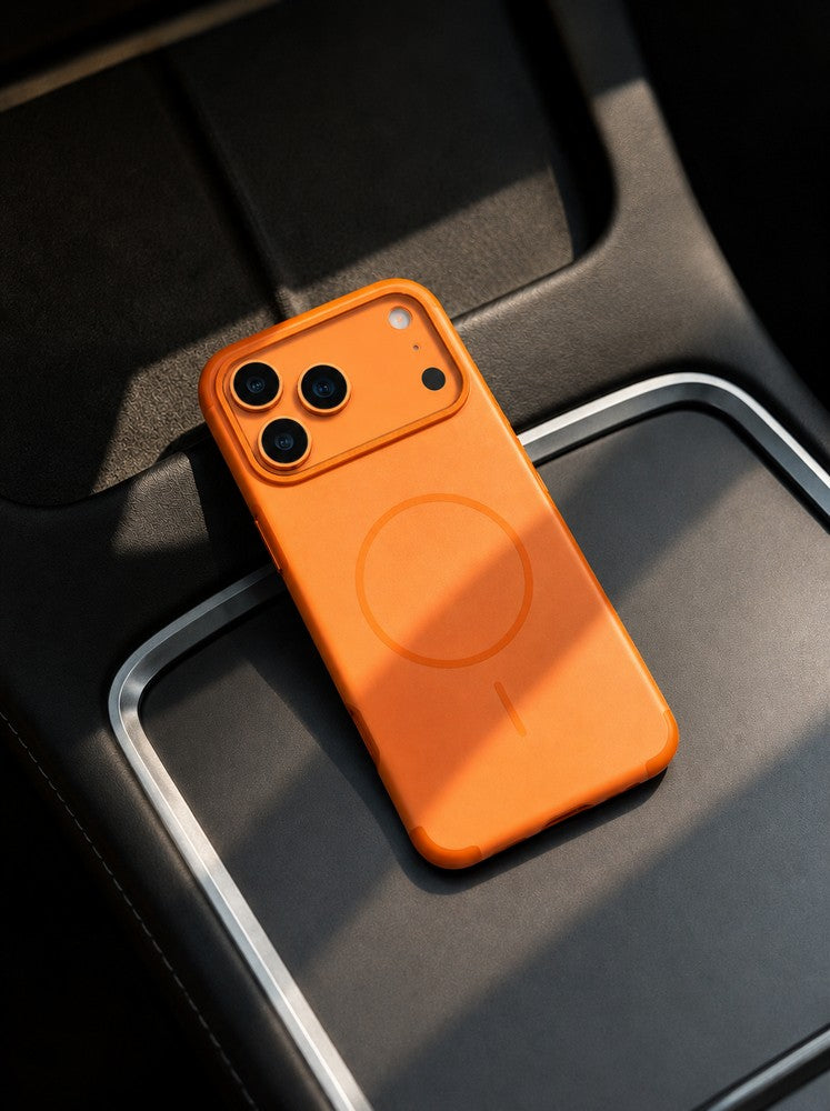 Üç kameralı turuncu bir telefon karanlık bir zeminde duruyor.