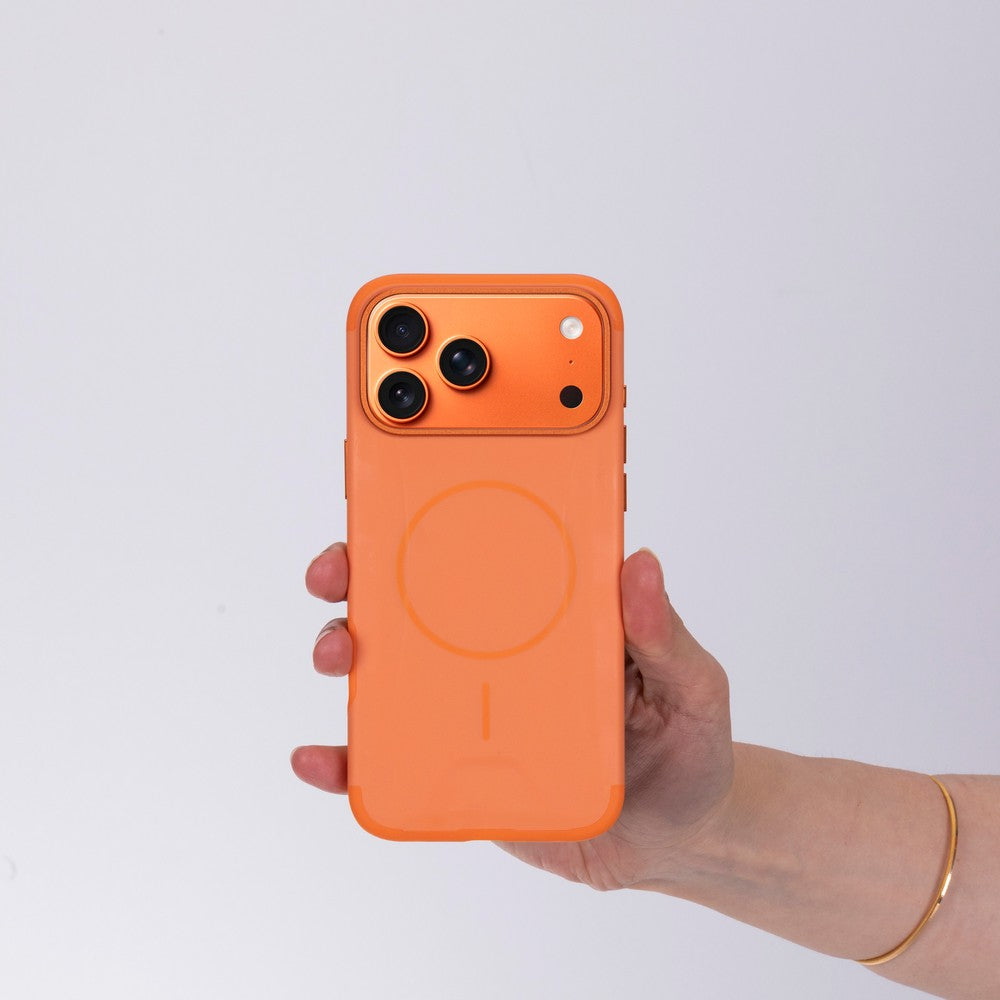 Bir el, beyaz arka plana karşı üç kameralı turuncu bir iPhone kılıfı tutuyor.