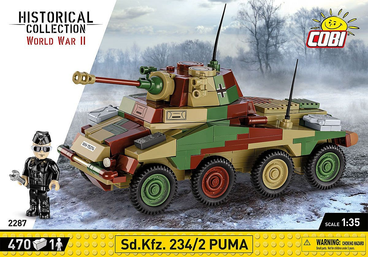 Ein Spielzeug-Militärfahrzeug, ein Sd.Kfz. 234/2 Puma, in Tarnfarben, mit einem Spielzeugsoldaten daneben.