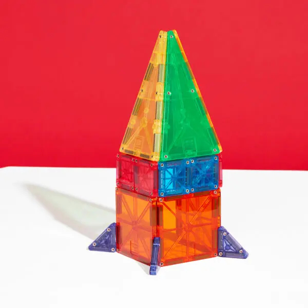 Une structure de fusée jouet magnétique colorée sur fond rouge.