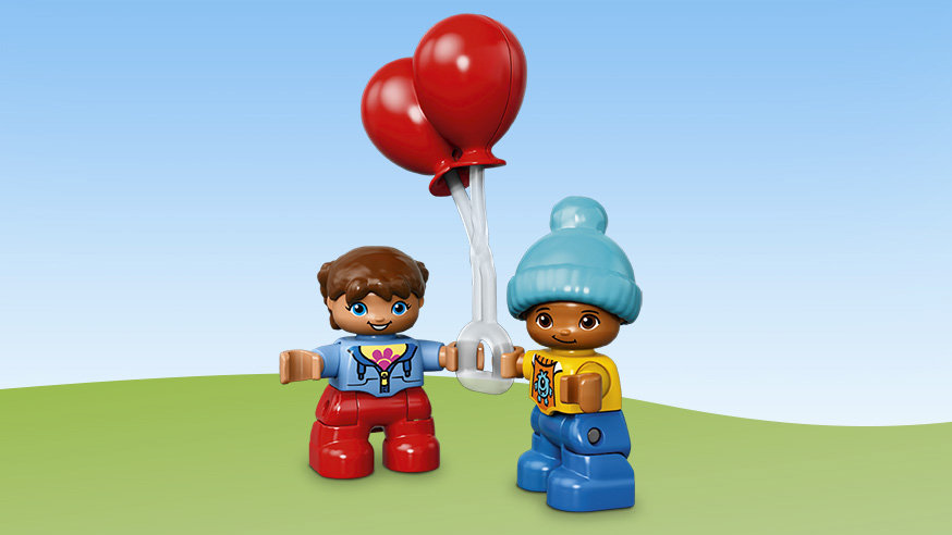 Due figure Duplo tengono palloncini rossi su uno sfondo blu.