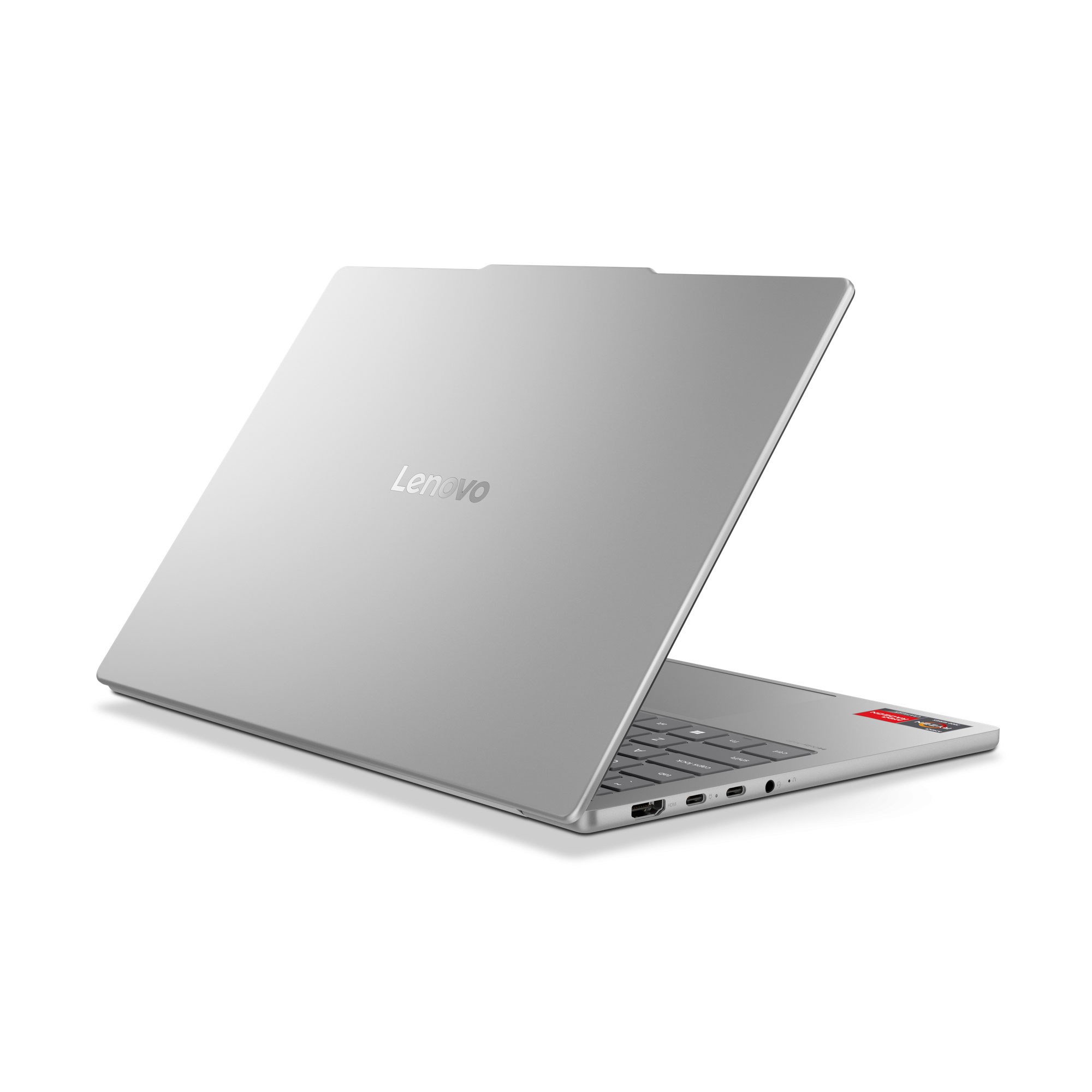Gümüş renkli bir Lenovo dizüstü bilgisayar, kapağında marka logosu ve klavye alanı görünür şekilde açık duruyor.